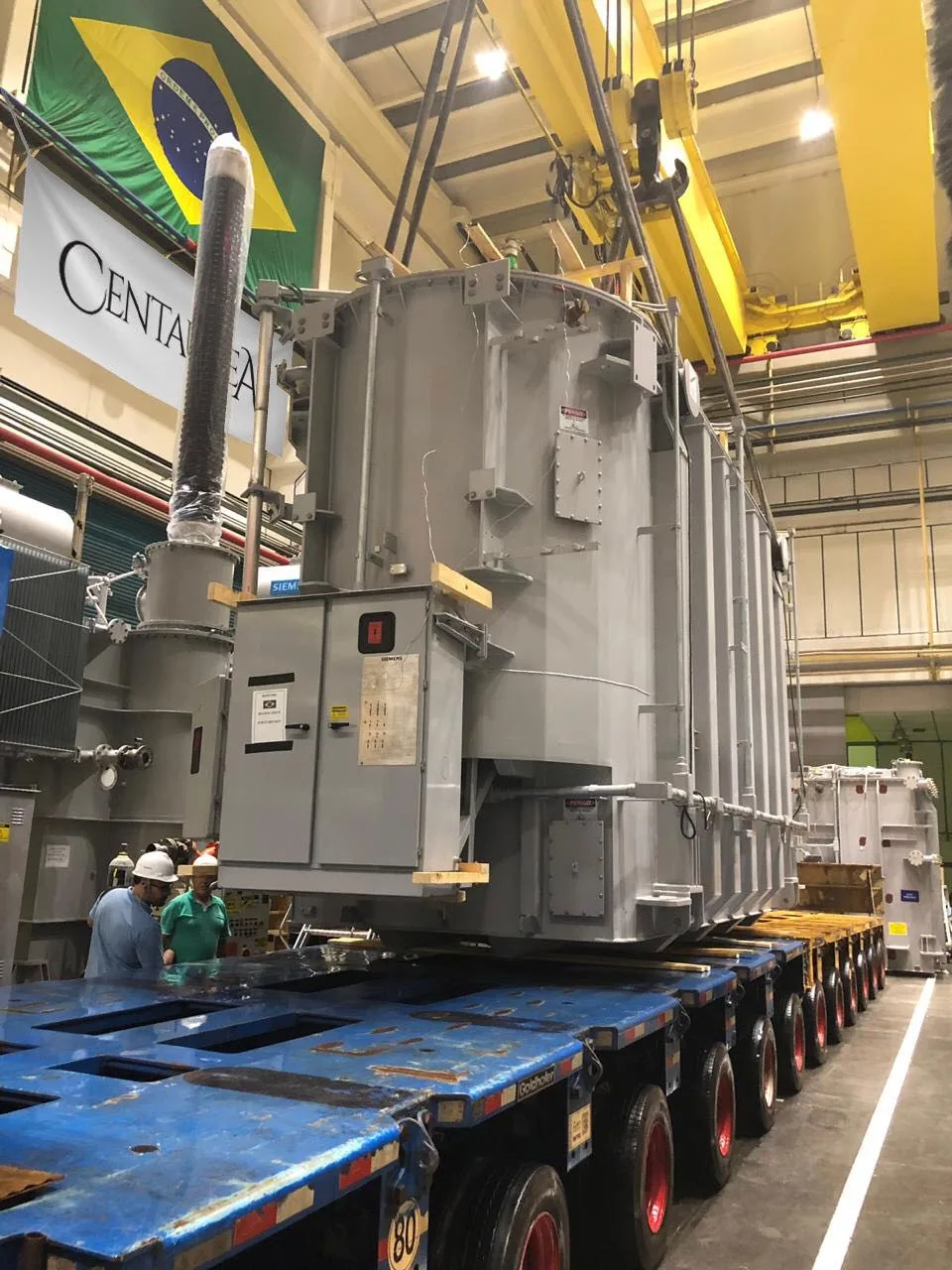 Transformador de potência posicionado sobre carreta hidráulica multieixo dentro de uma fábrica no Brasil